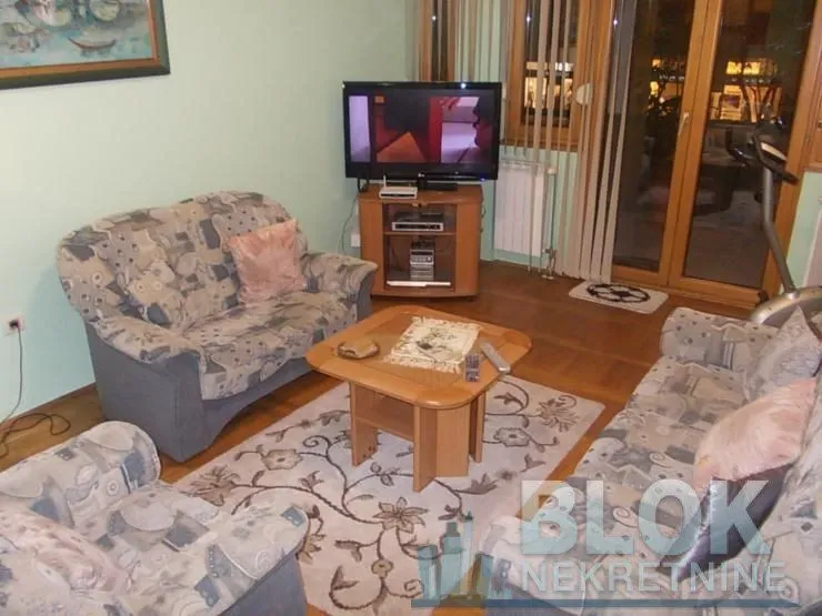 Living room with sofa set, coffee table and television.