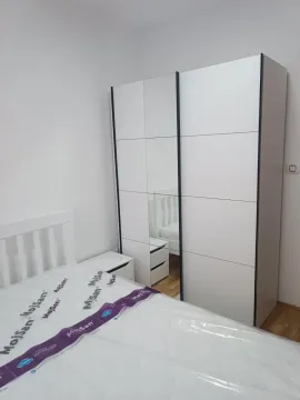 Bright bedroom with a bed and a white wardrobe. - image 5