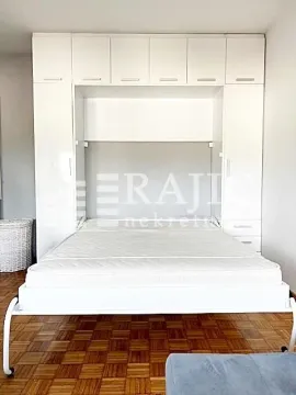 Bedroom with a wall bed and white wardrobe. - image 8