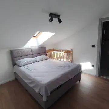 Bedroom with a double bed, roof window and a baby crib. - image 10