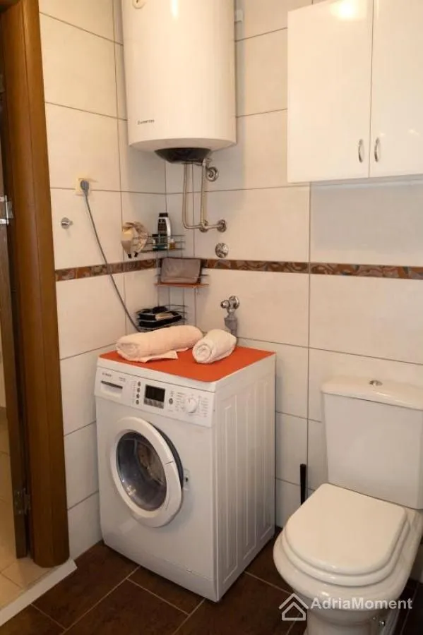 Kupatilo sa veš mašinom, bojlerom i toaletom.