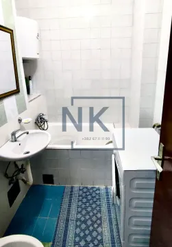 Smaller bathroom with a bathtub, washbasin, and washing machine. - image 5