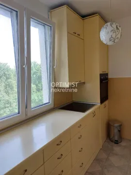 Manja kuhinja sa žutim elementima i prozorom koji gleda na zelenilo. - image 14