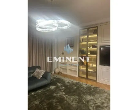 Living room with sofa, large chandelier and built-in cabinet with display case. - image 2