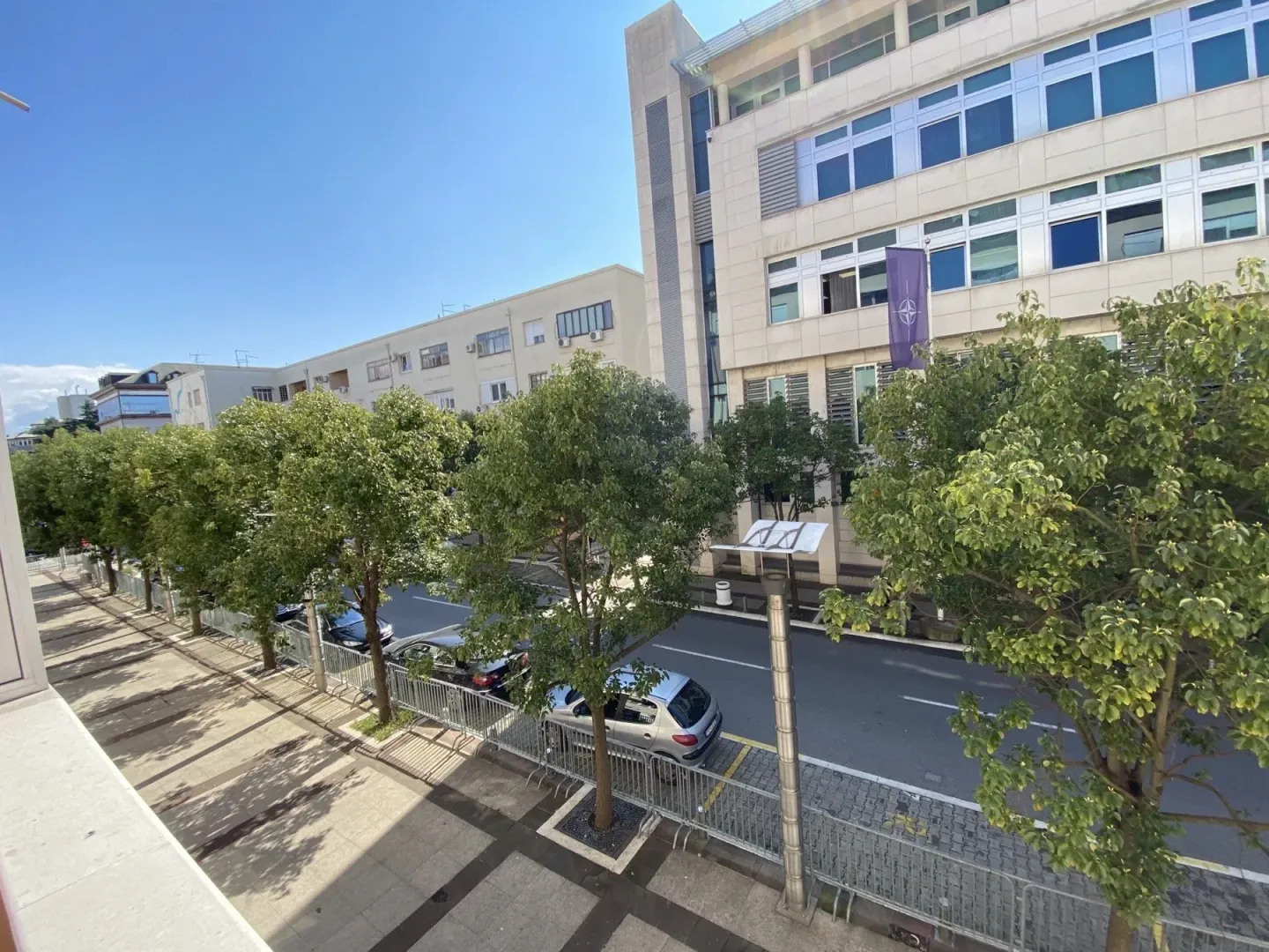 View of the street and trees from a terrace.