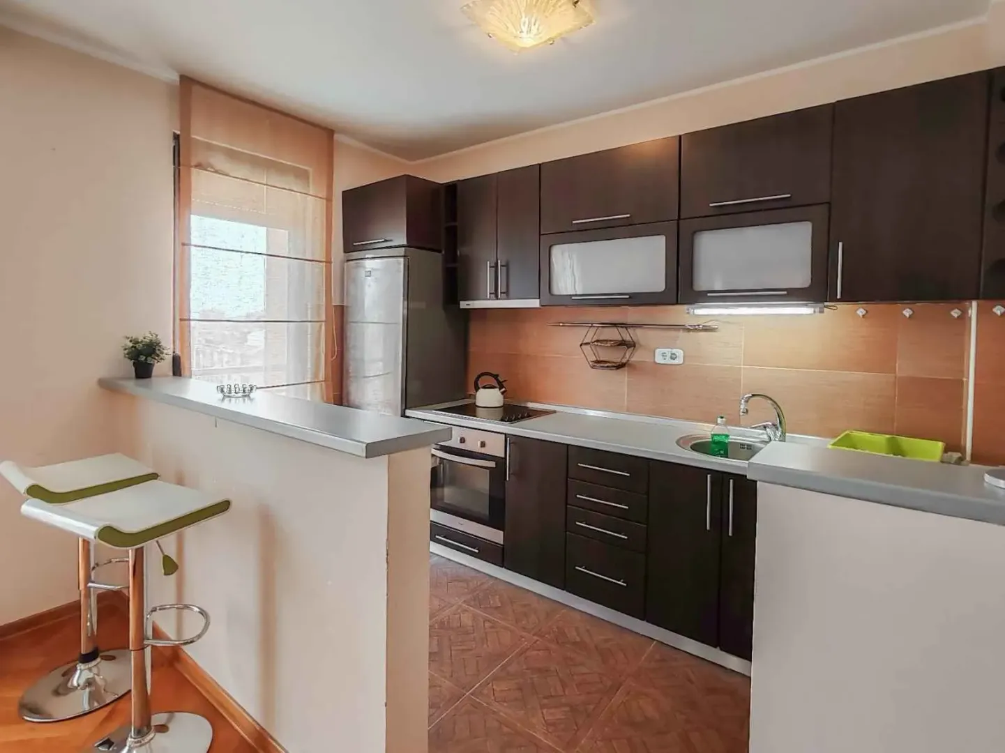 Kitchen with dark cabinetry and a breakfast bar with bar stools.