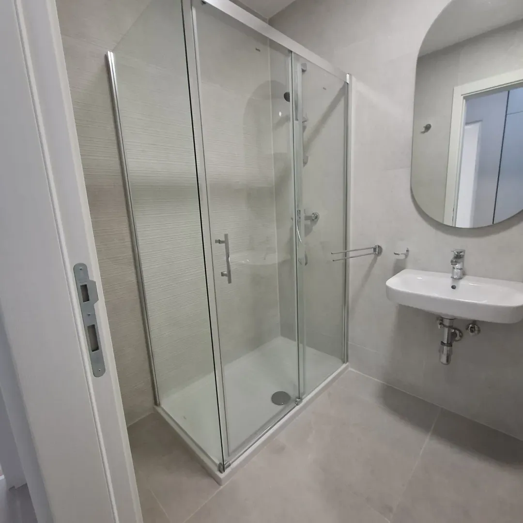 Modern bathroom equipped with a shower cabin and washbasin.