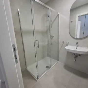Modern bathroom equipped with a shower cabin and washbasin. - image 6