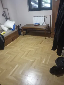 A room featuring parquet flooring, a bed, and a wooden table. - image 5