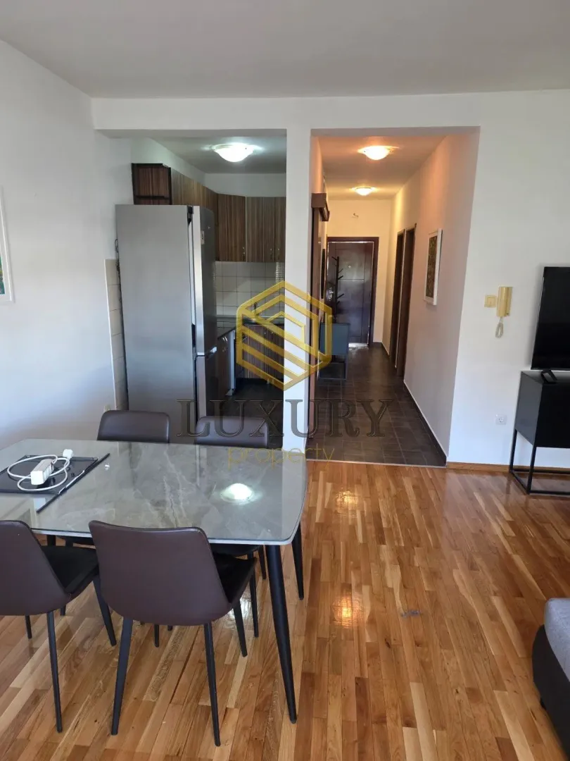 Living room with dining area and view of the kitchen and hallway.