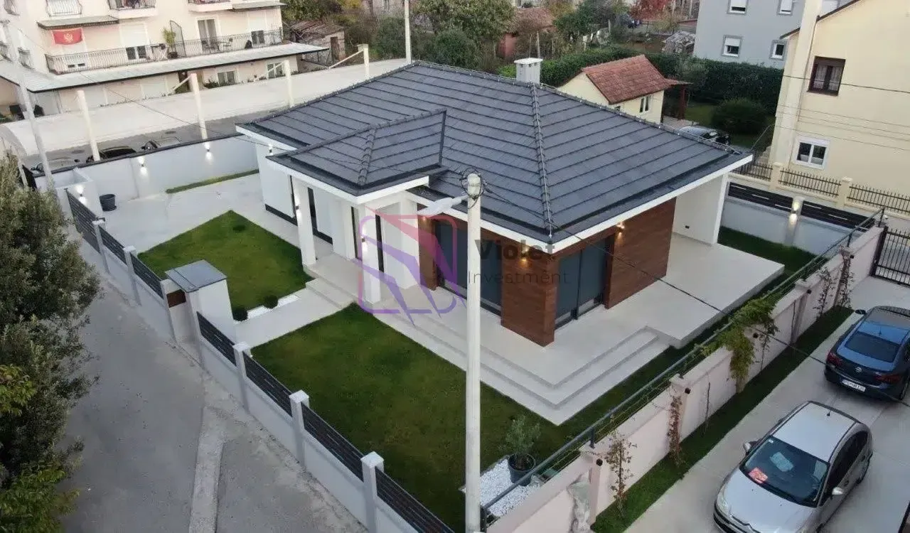 Pogled iz vazduha na prizemnu kuću sa uređenim dvorištem i ogradom.