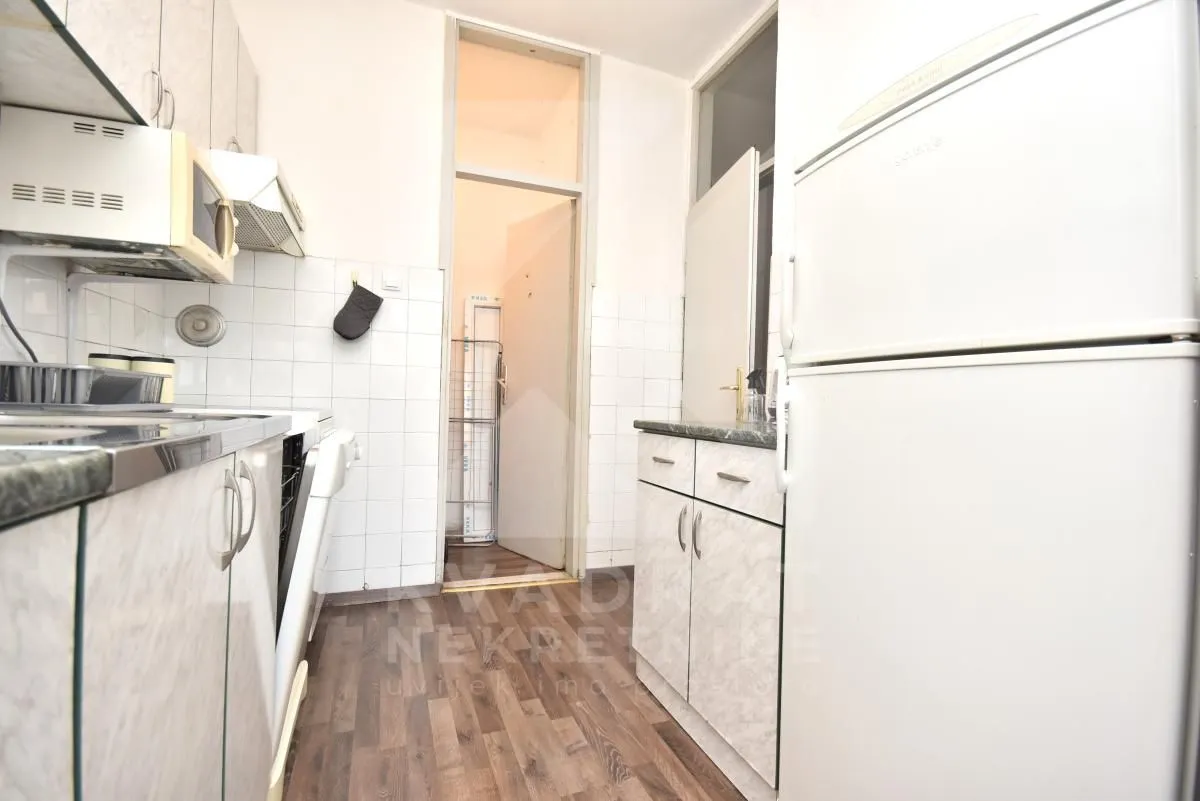 Small kitchen with white cabinets and a refrigerator.