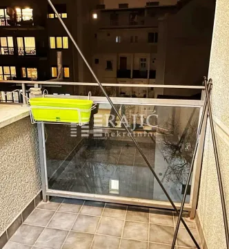 Smaller tiled balcony with railing and view of the neighboring building. - image 5