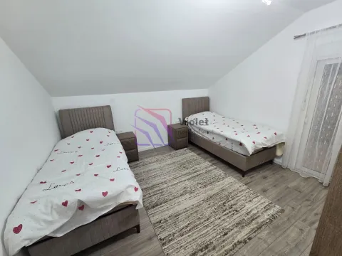 Bedroom with two single beds and a rug under a sloped ceiling. - image 9