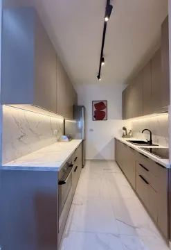 Modern kitchen with built-in cabinetry and marble countertops. - image 4