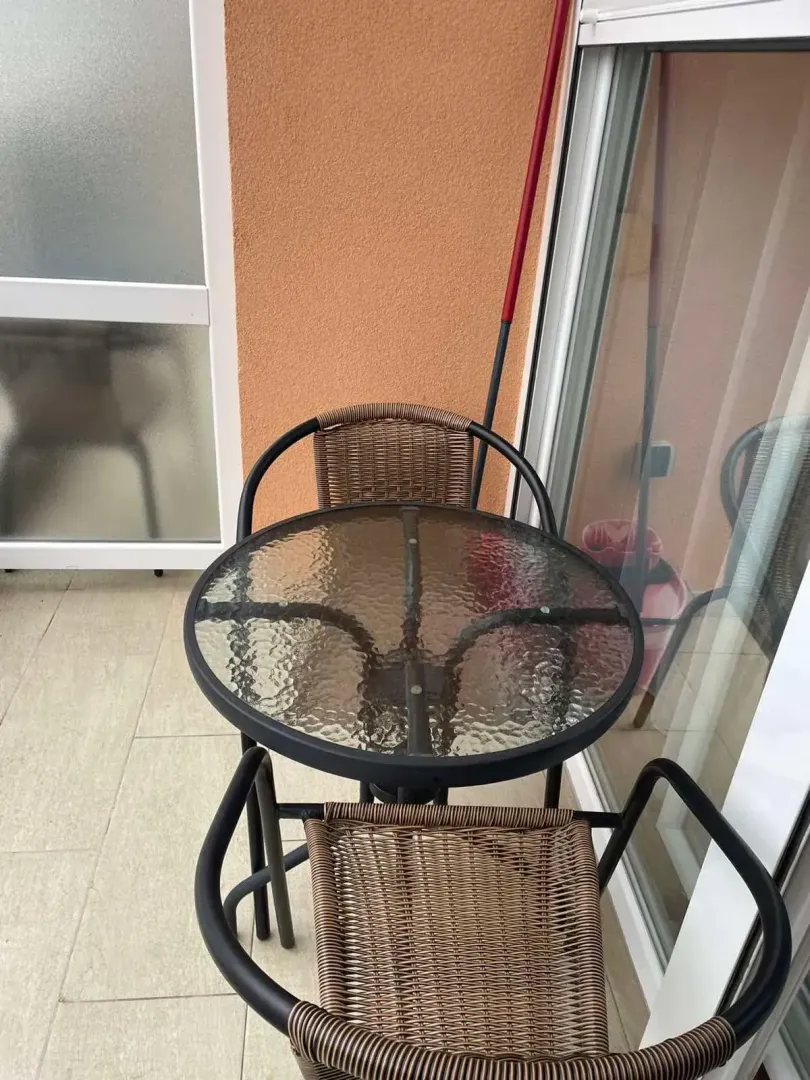 Manji sto sa dvije stolice na balkonu.