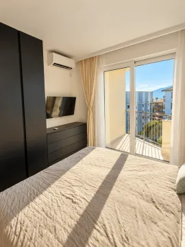 Bright bedroom with a double bed, wardrobe, and balcony access. - image 7