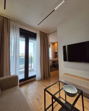 Modern living room with a sofa, TV, and access to the terrace. - image 5