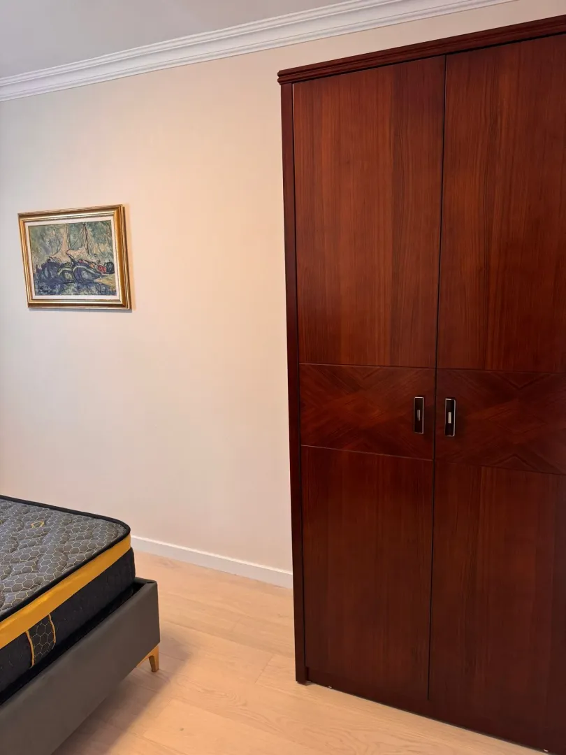 Bedroom with a large wooden wardrobe and a bed.