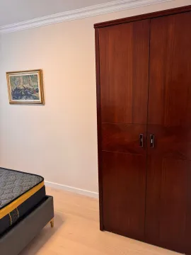 Bedroom with a large wooden wardrobe and a bed. - image 11