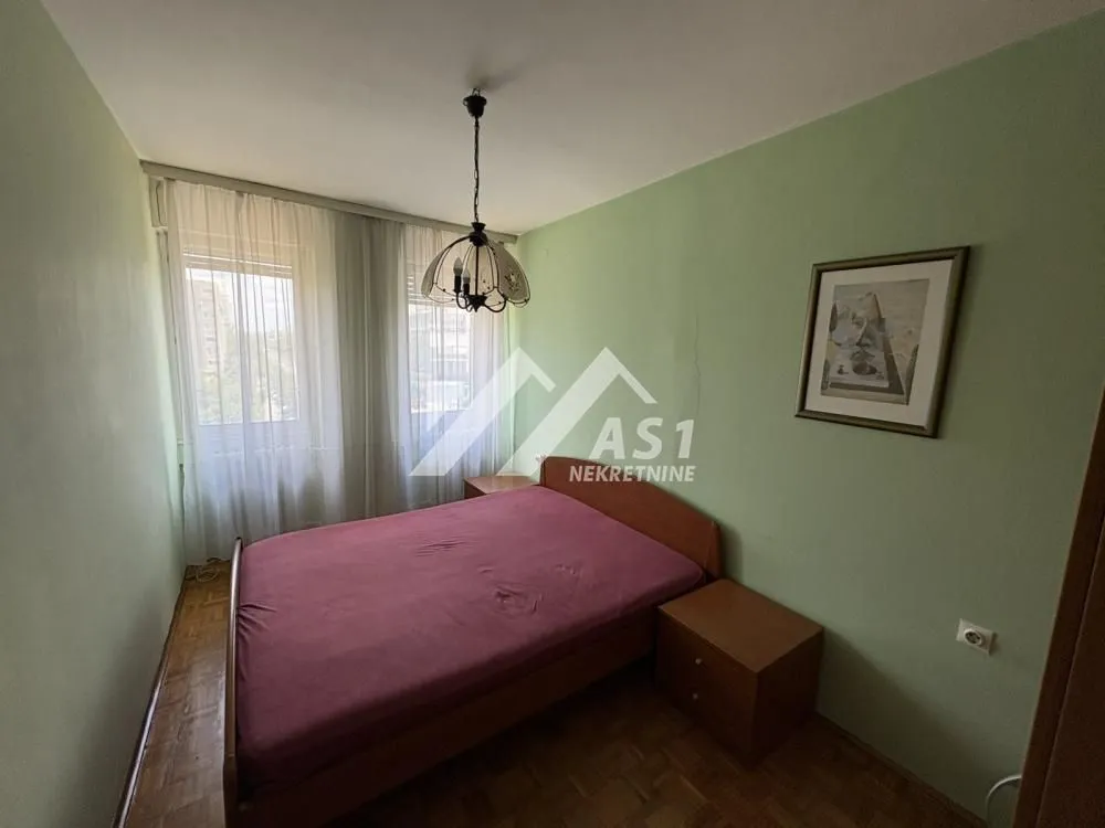 Bedroom with a double bed, bedside tables, and green walls.