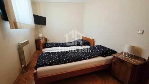 Spavaća soba sa dva kreveta i drvenim podom. - image 14