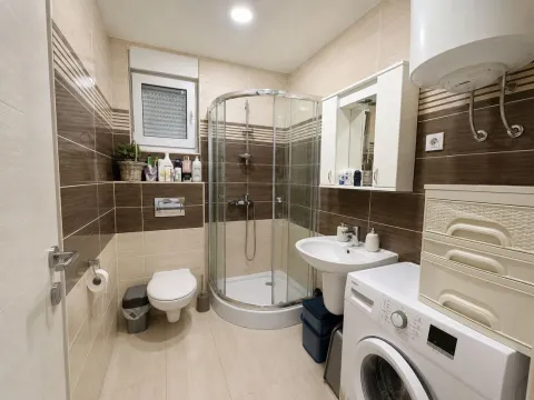 Kupatilo opremljeno tuš kabinom, umivaonikom, wc šoljom i veš mašinom. - image 4