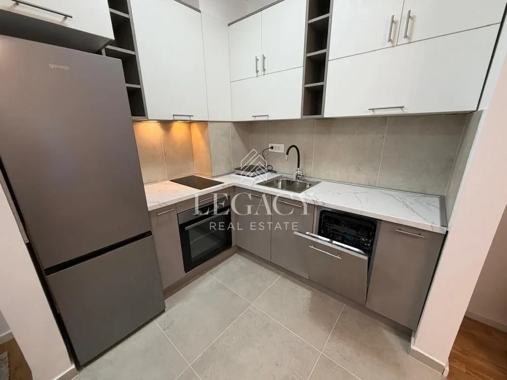 Small kitchen with white and grey cabinetry and a built-in refrigerator.