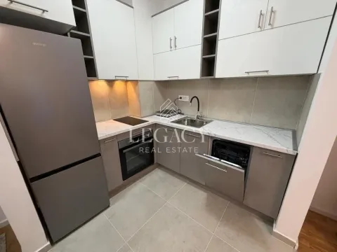 Small kitchen with white and grey cabinetry and a built-in refrigerator. - image 2
