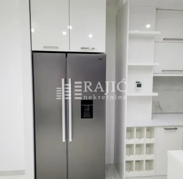 Modern kitchen with white cabinetry and a large refrigerator. - image 6