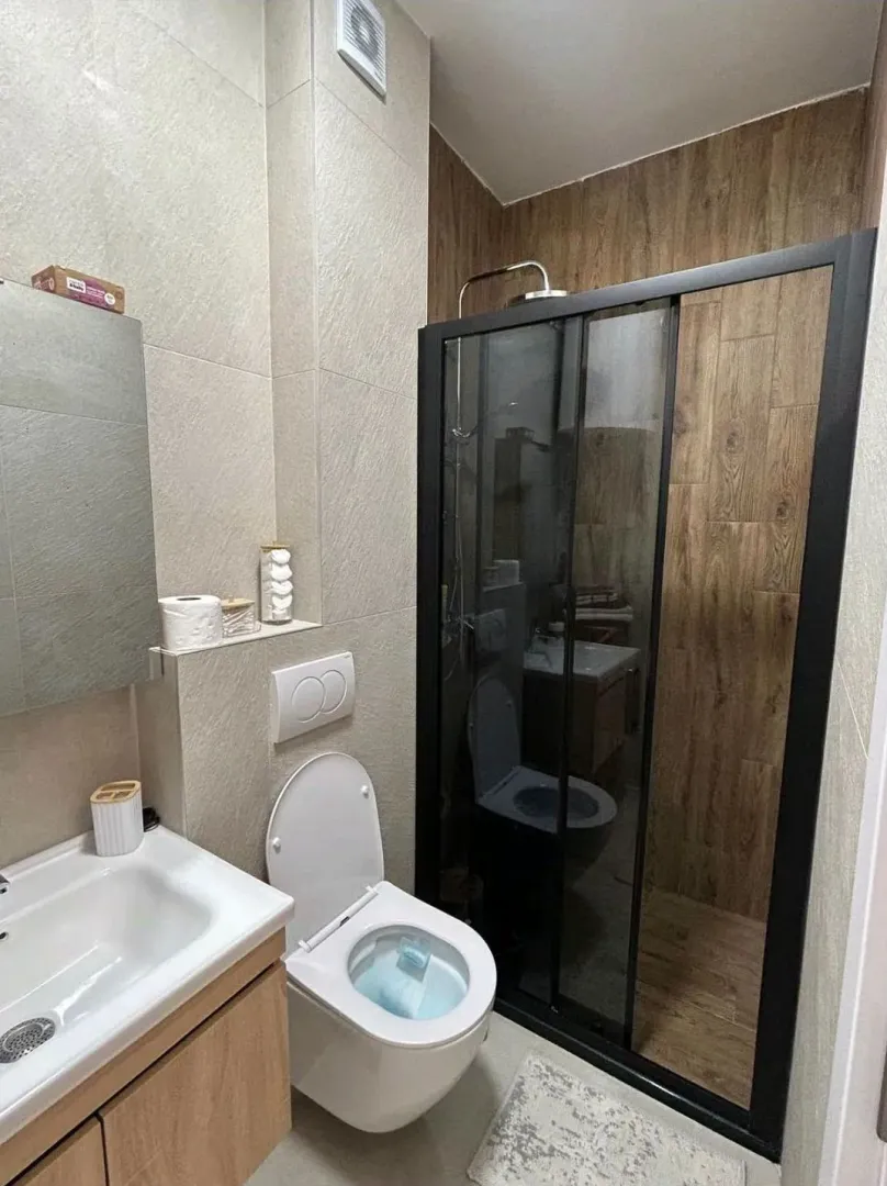Moderne kupatilo sa tuš kabinom, umivaonikom i wc šoljom.