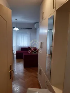 View from the hallway into the living room with a sofa and built-in wardrobe. - image 4