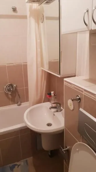 Compact bathroom with a bathtub, sink, and toilet.