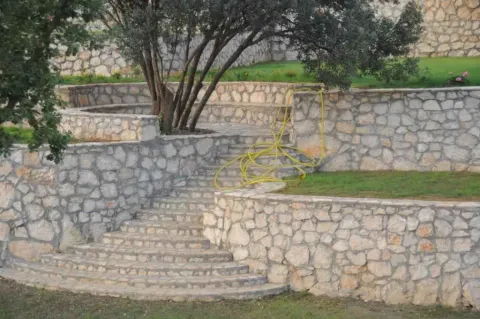 Terasasto uređeno dvorište sa kamenim zidovima i stepeništem. - image 6
