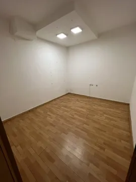 An empty room with laminate flooring and light walls. - image 4