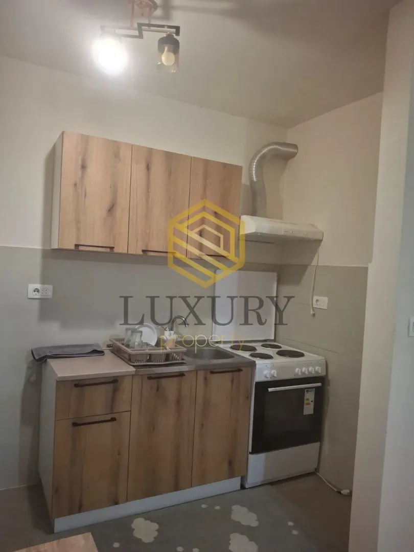 Small kitchen with wooden cabinets and a white stove.