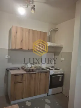 Small kitchen with wooden cabinets and a white stove. - image 3