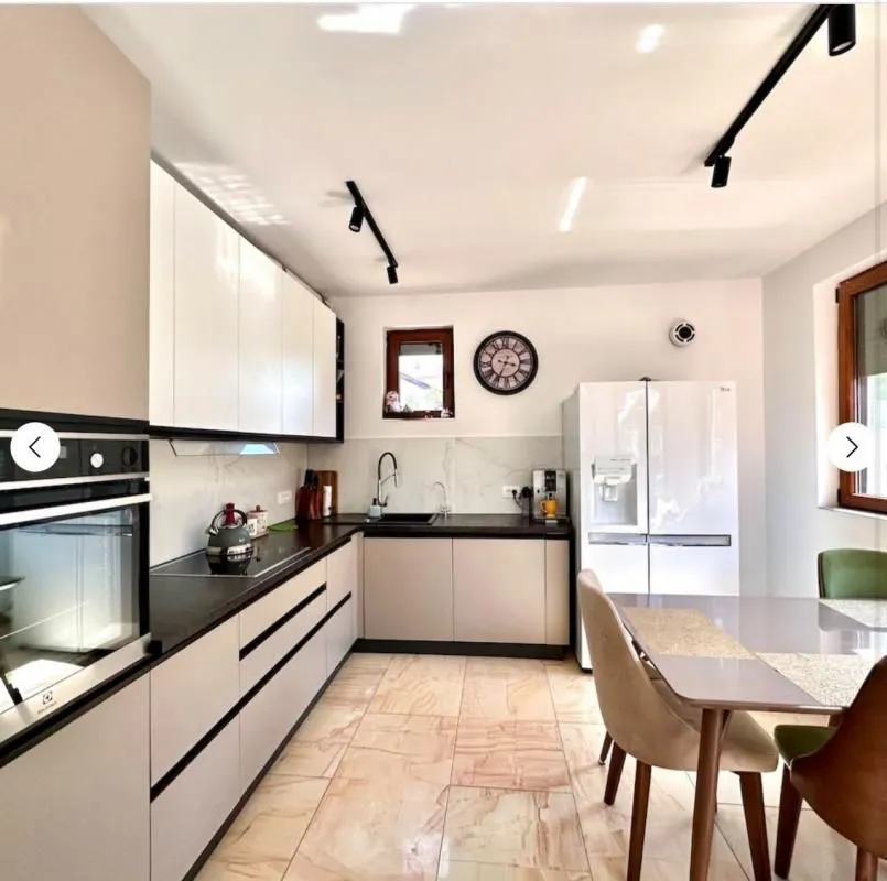 Modern kitchen with built-in appliances and a dining table.