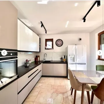 Modern kitchen with built-in appliances and a dining table. - image 4