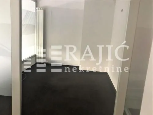 Empty room with dark flooring and white walls.