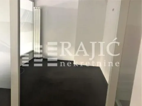 Empty room with dark flooring and white walls. - image 6