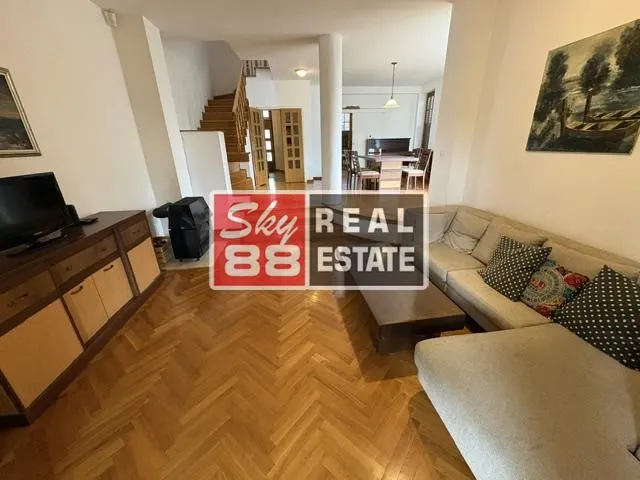 Living room with a sofa and a view towards the dining area and staircase.