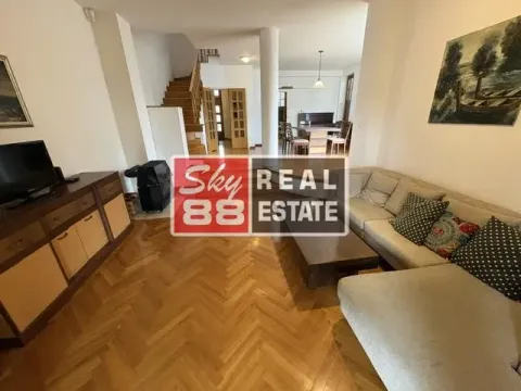 Living room with a sofa and a view towards the dining area and staircase. - image 3