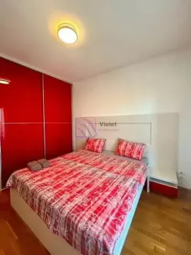 Furnished bedroom with a double bed and a built-in wardrobe with red doors. - image 5