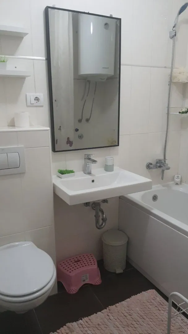 A simple bathroom with a bathtub, sink, and toilet.