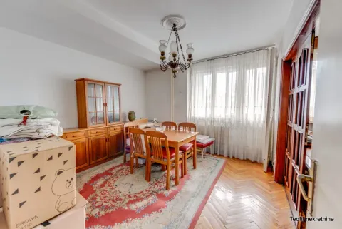Trpezarija sa drvenim stolom, stolicama i komodom u stanu. - image 14