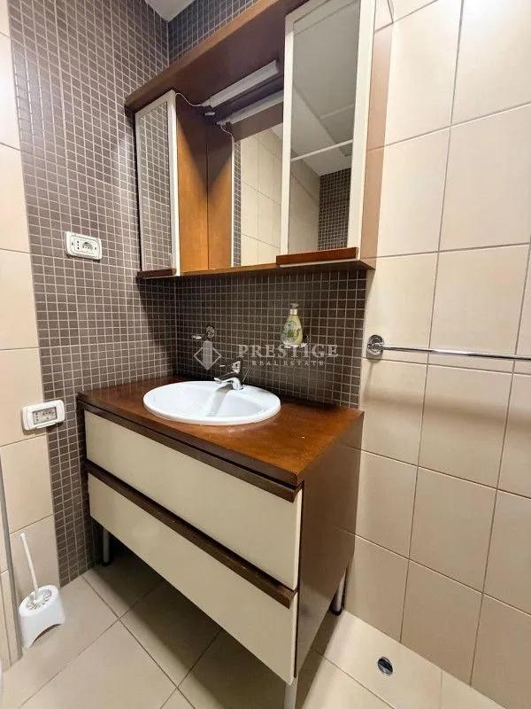 Kupatilo sa umivaonikom, ormarićem i ogledalom.