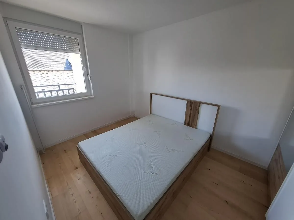 Spavaća soba sa bračnim krevetom i prozorom.