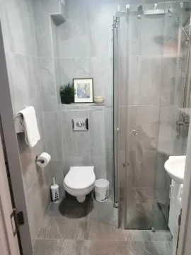 Moderno opremljeno kupatilo sa tuš kabinom i siva pločicama. - image 4