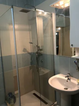 A bathroom featuring a glass shower cabin and a pedestal sink. - image 20